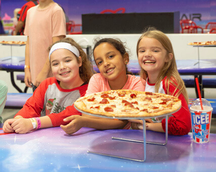 kids enjoying a pizza at cosmic air trampoline park during a group event